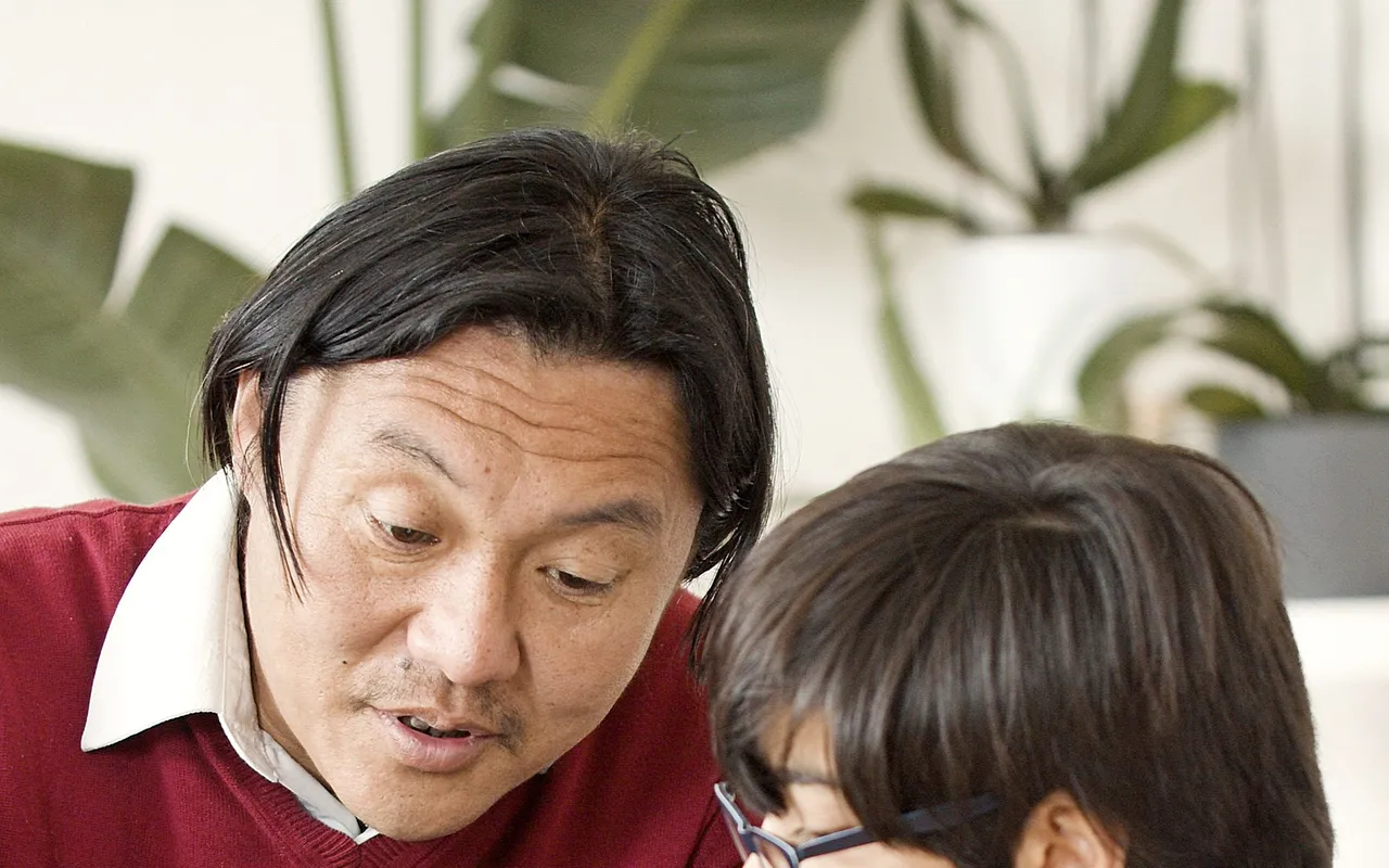 Photo — un parent et un jeune échangeant sereinement devant un ordinateur